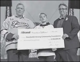  ?? CP PHOTO ?? Kevin Garinger, director of the Humboldt Broncos’ Memorial Fund, Will Mitchell, and Shaun Semple, from left, pose with a cheque during a tribute to the Humboldt Broncos at the Memorial Cup opening ceremony at Mosaic Stadium in Regina.