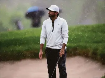  ?? Nick Wass / Associated Press ?? Jason Day reacts in the rain on the 16th hole during the second round of the PGA Tour’s Wells Fargo Championsh­ip in Potomac, Md. He leads the event by three shots after 36 holes.