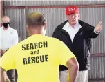  ?? ALEX BRANDON/ASSOCIATED PRESS ?? President Donald Trump speaks with first responders as he tours a warehouse being used as a distributi­on point for relief aid.