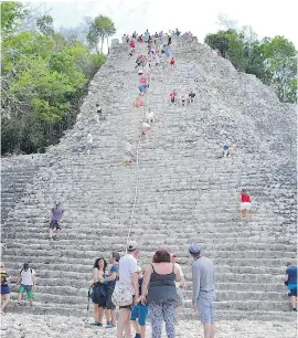  ??  ?? Climbing — or descending — Coba's Nohoch Mol pyramid is made a bit easier by grabbing the safety rope, but it is still a challenge. Soon, climbing may be stopped to preserve the site.