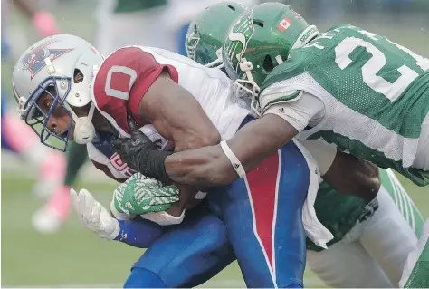  ?? MICHAEL BELL ?? Kevin Francis, right, tackles Montreal's Stefan Logan on Saturday. The Rider rookie has seen time on defence and special teams.