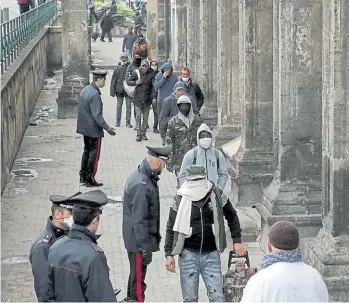  ?? REUTERS ?? Ayuda. Gente sin recursos hace fila en una calle de Nápoles para recibir alimentos