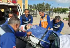  ?? AFP ?? An injured Palestinia­n is carried by stretcher into an ambulance by Egyptian paramedics at the Rafah border