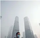  ??  ?? Protection: A man wears a mask outside during a hazy day in Shanghai.