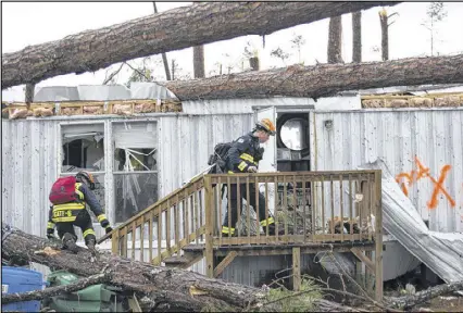  ?? BRANDEN CAMP / ASSOCIATED PRESS ?? Rescue workers prepare to enter a mobile home Monday to search for survivors at Big Pines Estates in Albany. Fire and rescue crews were searching through the debris Monday, looking for people who might have become trapped when the storm came through.
