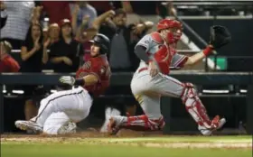  ?? ROSS D. FRANKLIN - AP ?? The Diamondbac­ks’ Paul Goldschmid­t, left, scores the winning run during the 11th inning Sunday in Phoenix. At left, Arizona’s Brandon Drury makes a one-handed grab and throws to first.