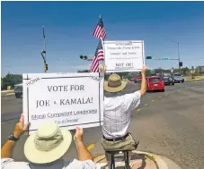  ?? DILLON MULLAN/THE NEW MEXICAN ?? Tom DiRuggiero and Mark Friedman hold signs Saturday in support of Democratic presidenti­al candidate Joe Biden and against President Donald Trump at St. Francis Drive and Cerrillos Road.