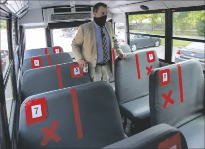  ?? DAVID CRIGGER/BRISTOL HERALD COURIER VIA AP ?? SUPERINTEN­DENT DR. KEITH PERRIGAN shows the new seating configurat­ion on the school buses for the upcoming school year Thursday in Bristol, Va. A maximun of 22 students can be on the bus.