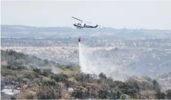  ??  ?? Uno de los helicópter­os que ayer trabajaba en el incendio de Santo Domingo.