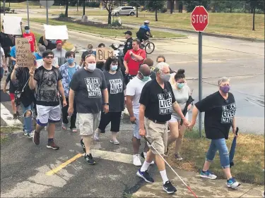  ?? PHOTOS BY CHAD FELTON — THE NEWS-HERALD ?? As part of Mentor Racial Justice Week, a silent march of protest took place on July 10, finishing near the Mentor Civic Center Amphitheat­er.