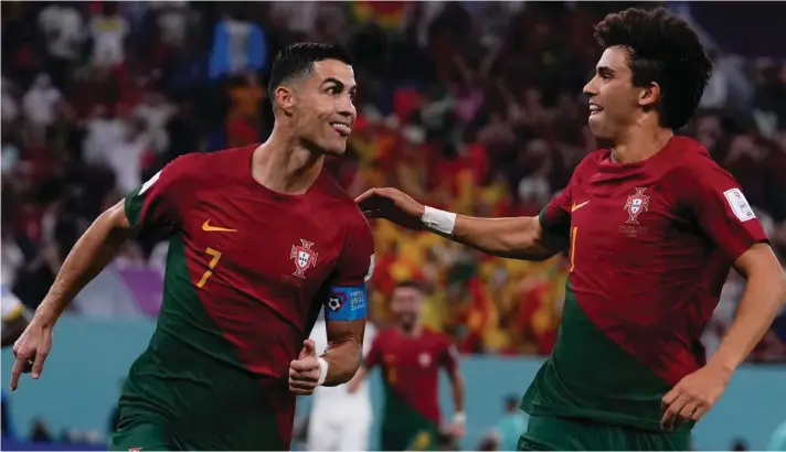  ?? ?? Portugal's Cristiano Ronaldo, left, celebrates with teammate Joao Felix after scoring from the penalty spot his side's opening goal against Ghana during a World Cup group H soccer match at the Stadium 974 in Doha, Qatar, Thursday, Nov. 24, 2022. (AP Photo/Manu Fernandez)