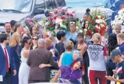  ?? KEITH SRAKOCIC/ASSOCIATED PRESS ?? People carry flowers to the cars as they leave the funeral for Antwon Rose Jr. on Monday in Swissvale, Pa. Rose was fatally shot by a police officer on June 19.