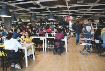  ?? AFP ?? Customers eat at a restaurant at the new IKEA store in Hyderabad yesterday. Curious customers lay on beds and nestled into armchairs as Ikea opened its first Indian outlet.