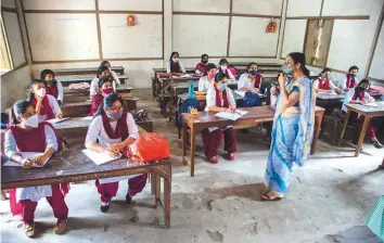  ?? AP ?? Students wearing masks as a precaution against the coronaviru­s attend a class on the first day of partial reopening of schools in Guwahati, Assam, on Monday.