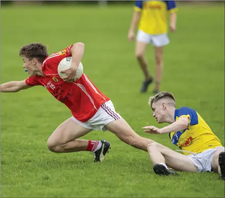  ?? Photo by Domnick Walsh ?? Luke Crowley, East Kerry, tries to evade the tackle of Sean O’Mahony, Feale Rangers (yellow), during their County Minor Football championsh­ip quarter-final played in Finuge on Monday evening.