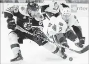  ?? Michael Dwyer Associated Press ?? A LOOSE puck sparks a battle between Boston’s Brad Marchand, left, and Ottawa’s Cody Ceci.