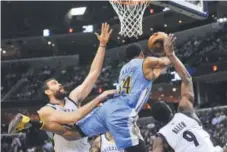  ?? The Associated Press ?? Nuggets guard Gary Harris is sandwiched between two Grizzlies players Friday inMemphis, Tenn. Brandon Dill,