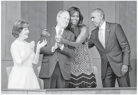  ?? PabloMarti­nez / Associated Press ?? First ladyMichel­le Obama embraces former President GeorgeW. Bush as President Barack Obama and former first lady Laura Bush join them on stage at the dedication ceremony of the Smithsonia­nMuseum of African American History and Culture on Saturday.