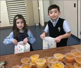  ?? PHOTO FROM ST. TERESA OF CALCUTTA PARISH SCHOOL ?? Students at St. Teresa of Calcutta School filled bags with food to be donated to Open Door Ministry in Royersford. The project was part of a day of outreach during Catholic Schools Week.