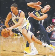  ?? Jack Dempsey, The Associated Press ?? Golden State’s Klay Thompson drives past Nuggets defender Nikola Jokic on Saturday night.