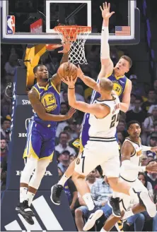  ?? Justin Tafoya / Getty Images ?? Alfonzo McKinnie (left) and Jonas Jerebko contest a shot by the Nuggets’ Mason Plumlee last month in Denver.