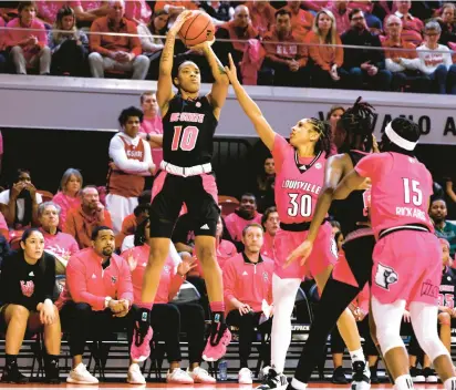  ?? LANCE KING/GETTY ?? North Carolina State guard Aziaha James puts up a 3-point shot against Louisville guard Jayda Curry during Monday night’s game. It was James’ fifth game this season with at least 20 points.