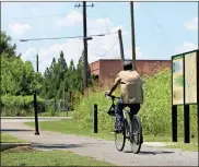  ??  ?? ABOVE: A cyclist rides toward the existing terminus of the current paved trail system which runs by Silver Creek and connects with the Kingfisher trails which connect downtown. RIGHT: Funds to replace the current dock at Lock and Dam Park are part of the 2017 SPLOST.