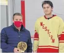  ?? JASON SIMMONDS • THE GUARDIAN ?? Island Junior Hockey League commission­er Jordan Ellis, left, presents Arsenault’s Fish Mart Western Red Wings forward Silas Handrahan with the MVP award for the playoffs. Handrahan recorded 20 points and had at least one point in eight of his team's nine post-season games. The Red Wings defeated the Sherwood-Parkdale A&S Scrap Metal Metros 6-1 on Wednesday night to clinch the franchise’s fourth straight provincial title.