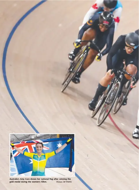  ?? Picture: AP PHOTO ?? Australia's Amy Cure shows her national flag after winning the gold medal during the women's 10km.