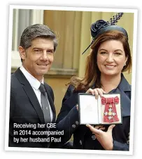  ?? ?? Receiving her CBE in 2014 accompanie­d by her husband Paul