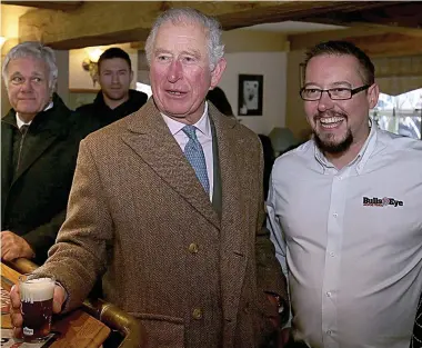  ?? Pictures: NIGEL RODDIS ?? Prince Charles enjoys a beer at the Hare & Hounds pub which helped Fishlake residents