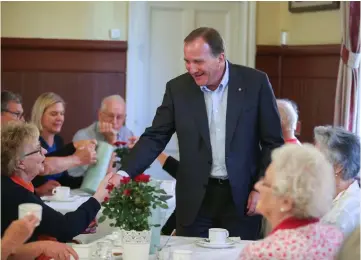  ??  ?? Lofven drinks coffee and talks with citizens during election day in Sundbyberg, Sweden. —