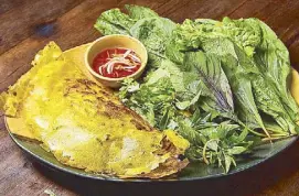  ??  ?? Banh xeo is a savory crepe filled with meat, shrimp, herbs and fresh mustard leaves.