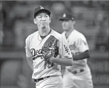  ?? Victor Decolongon Getty Images ?? KENTA MAEDA MIGHT have known it wasn’t going to be a good night for him or the Dodgers as he heads back to the dugout after the first inning. The Reds had taken a 1-0 lead on Joey Votto’s run-scoring single.