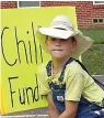  ??  ?? ■ Rowdy Haley, 9, is putting out the signs for his “best chili dog in the world” sale in Linden, Texas.