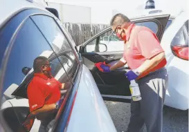  ??  ?? Above: Armando Cruz sanitizes the inside of a selfdrivin­g Waymo Jaguar IPace after a test drive. Top: A Jaguar IPace arrives at a temporary location in South San Francisco. Waymo is ramping up testing of its autonomous cars.