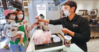  ?? ZHU XINGXIN / CHINA DAILY ?? A consumer buys tea at a shop in Shanghai’s Jinshan district on Monday.