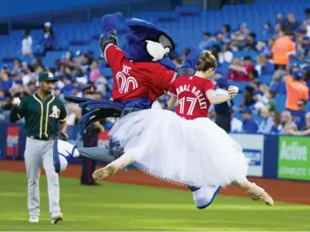  ?? CARLOS OSORIO PHOTOS/TORONTO STAR ?? Heather Ogden, a principal dancer with the National Ballet of Canada, dances off the field with Blue Jays mascot Ace after she threw out the first pitch Tuesday at the Rogers Centre.