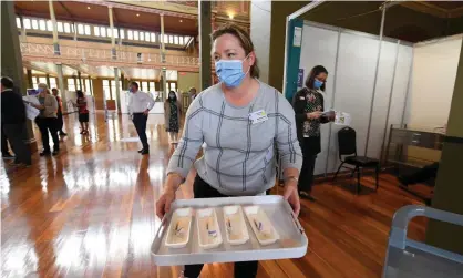  ?? Photograph: James Ross/EPA ?? A healthcare worker transports Covid-19 vaccines to injecting rooms inside of the Royal Exhibition Building in Melbourne in March. The federal government has signalled it wants to work with states and territorie­s to set up mass vaccinatio­n clinics.