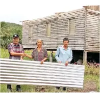  ??  ?? JELANI menyampaik­an bantuan zink kepada seorang mangsa ribut di Kg Rondomon, Matunggong.