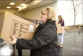  ??  ?? Reading YMCA Director of Developmen­t Michele Reinert loads a donation of Heat Holders socks at Boscov’s East on January 14.