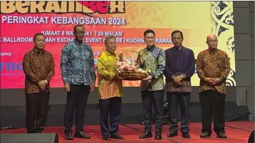  ?? ?? Dr Sim (third left) presents a memento to Wong on stage, as other guests look on.