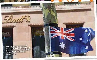  ??  ?? A flag bearing the names of victims Tori (Johnson) and Kate (Katrina Dawson) waves outside the Lindt Cafe in Sydney’s Martin Place.