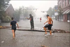  ?? Chris Seward / Associated Press ?? People survey the damage caused by Hurricane Florence on Front Street in downtown New Bern, N.C., on Friday.