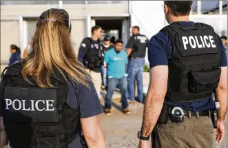  ?? PHOTOS BY JOHN MINCHILLO / ASSOCIATED PRESS ?? Government agents take a suspect into custody during an immigratio­n sting at Corso’s Flower and Garden Center on Tuesday in Castalia, Ohio. The operation is one of the largest against employers in recent years on allegation­s of violating immigratio­n...