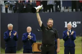  ?? JON SUPER — THE ASSOCIATED PRESS ?? Ireland’s Shane Lowry smiles as he holds the Claret Jug trophy aloft after being presented with it for winning the British Open Golf Championsh­ips at Royal Portrush in Northern Ireland, Sunday.