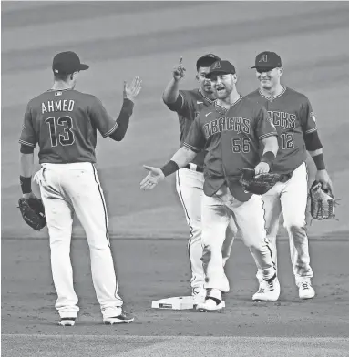  ?? ROB SCHUMACHER/THE REPUBLIC ?? The Diamondbac­ks’ Kole Calhoun (56) celebrates with his teammates after Arizona defeated Texas at Chase Field in Phoenix on Wednesday.