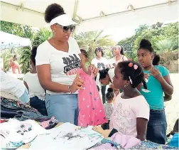  ??  ?? Tanya Graham helping this little girl choose the perfect outfit.