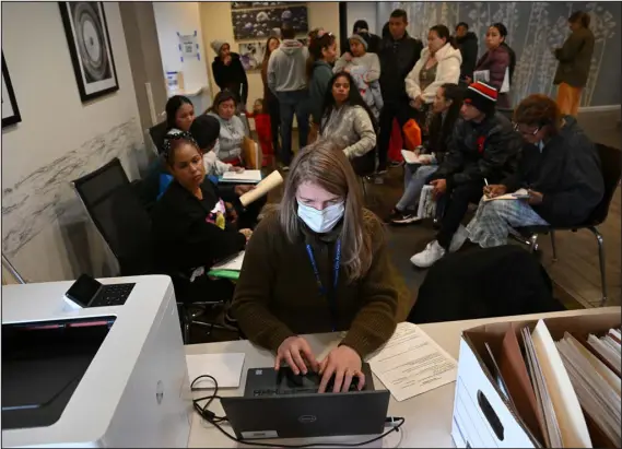  ?? HELEN H. RICHARDSON — THE DENVER POST ?? Volunteer Snezhanna Singleton helps process Venezuelan migrants beginning the work permitting process.