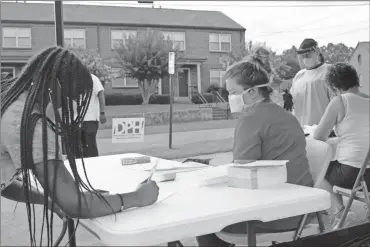  ?? John Bailey ?? People steadily signed up to receive a free COVID-19 test at a Department of Public Health pop-up testing center at John Graham Homes in East Rome early Wednesday. The DPH partnered with the Northwest Georgia Housing Authority’s Envision Center program to address testing disparitie­s in the community.